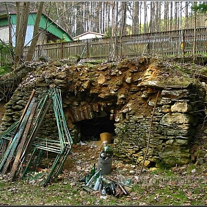 Pozůstatek základů a sklepa pily, v pozadí dětský tábor.