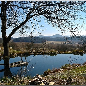 Rybníček v bývalém středu polozaniklé vísky s pozadím Orlovické hory a Jezvince.